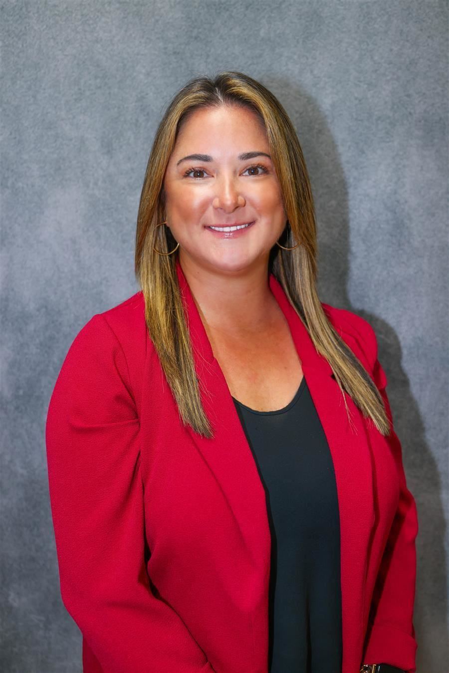  Stephanie Pizza smiles to camera while wearing a blazer.